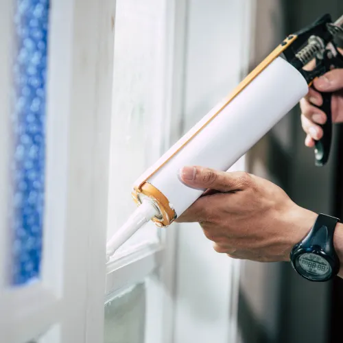 imagen de persona sellando ventana con silicona.